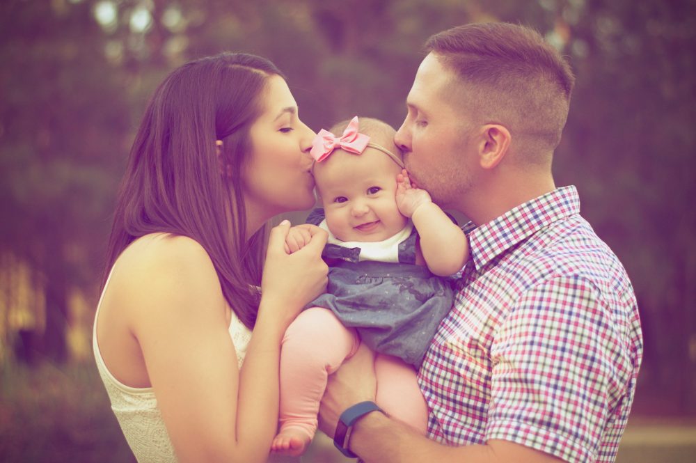 Family kissing baby